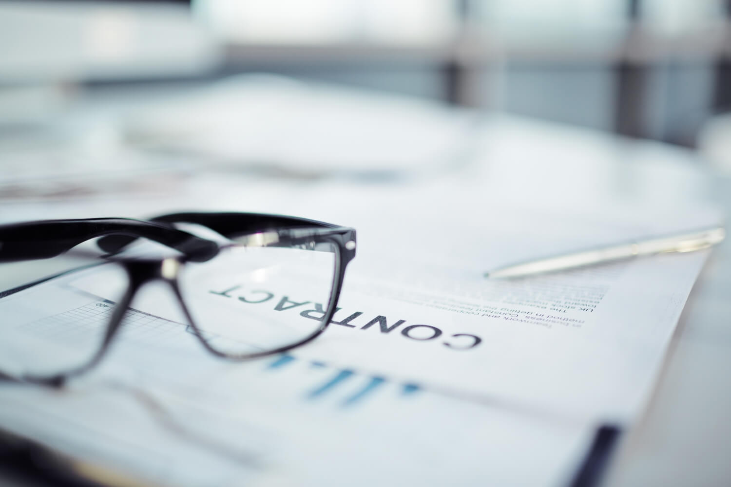 Ein Stift und eine Brille auf einem Tisch.