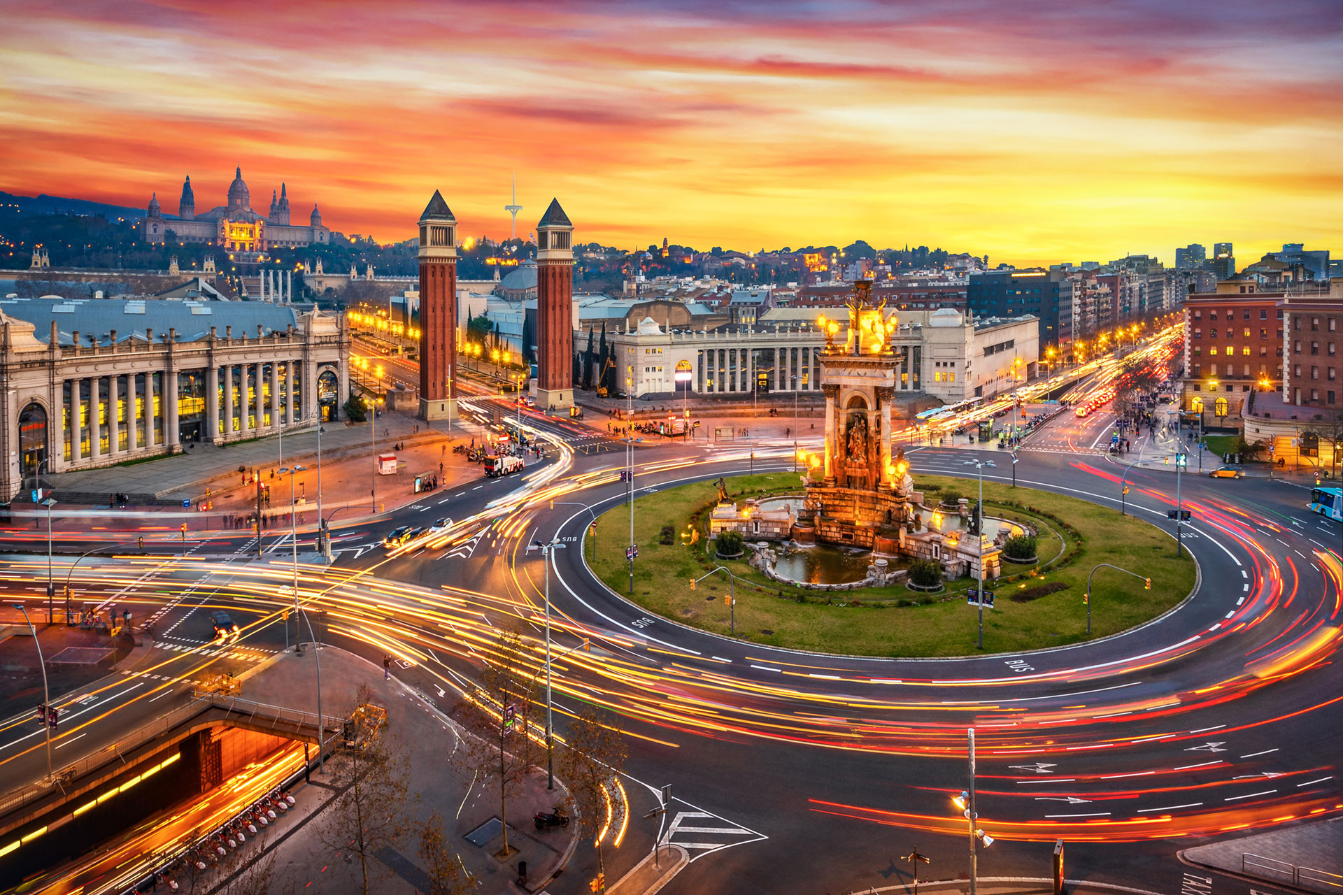Stadt mit Kreisverkehr und Statue im Freien bei bewölktem Himmel.