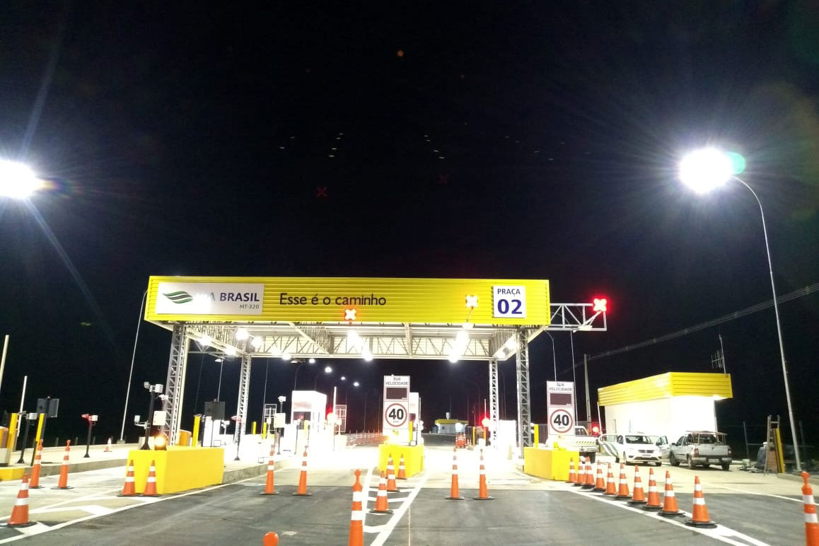 Señal amarilla y blanca en una estación de peaje.