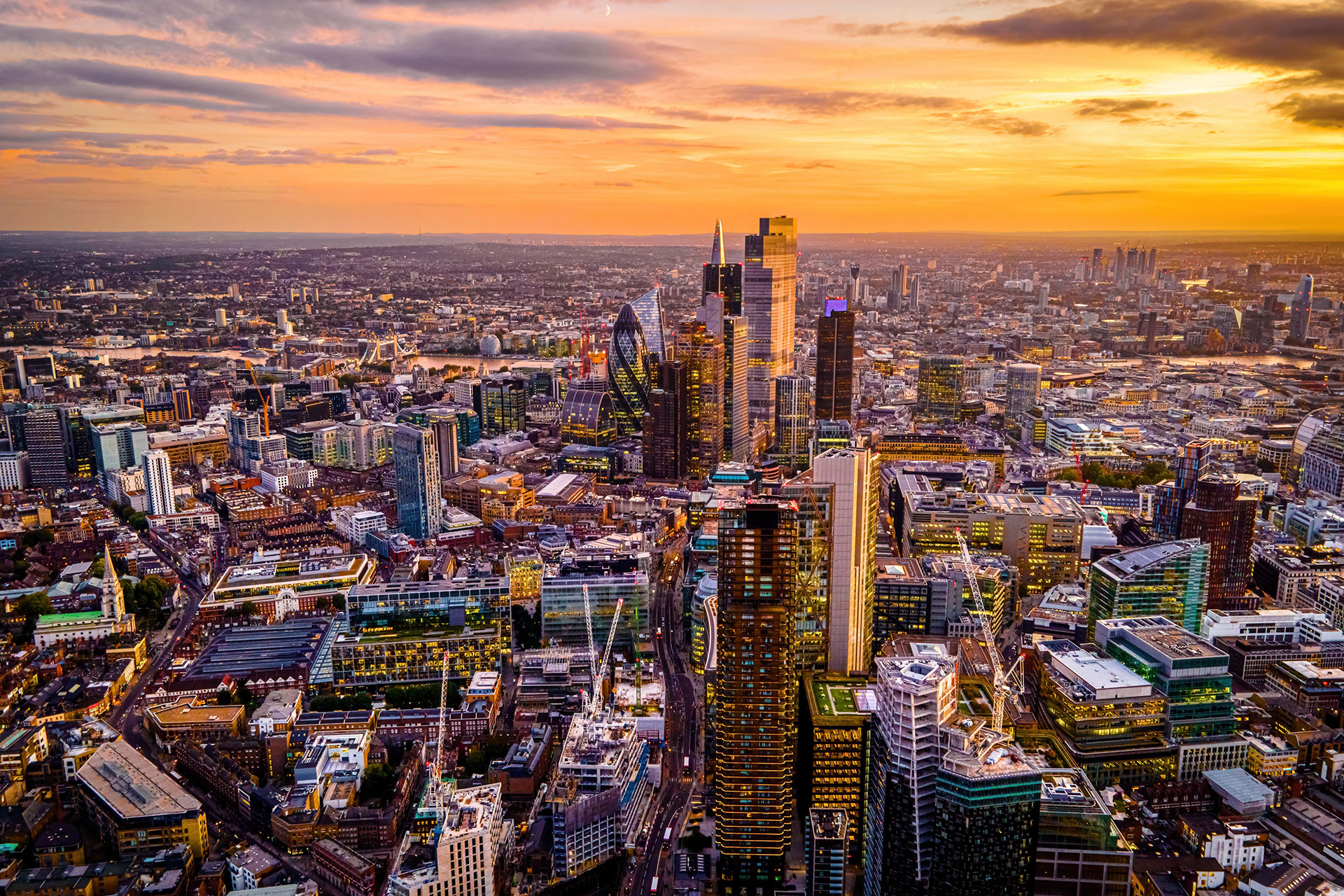 Stadtansicht mit vielen hohen Gebäuden bei Sonnenuntergang.