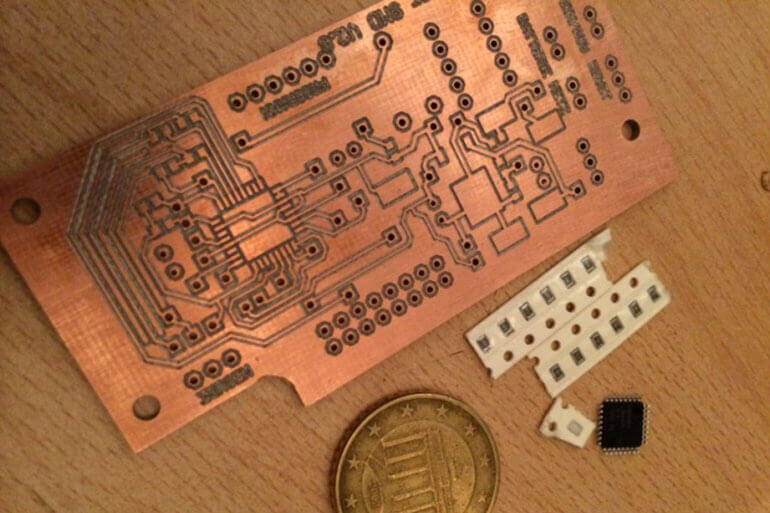 Kupferne Leiterplatte mit kleinen Chips und einer Münze