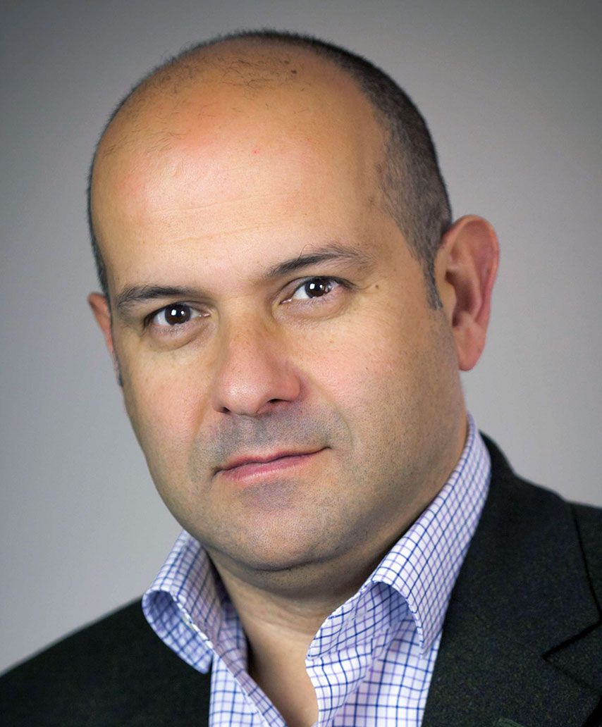 A man in a suit with a dress shirt and necktie.